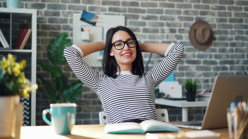 A business owner relaxing at her desk after automating her booking admin